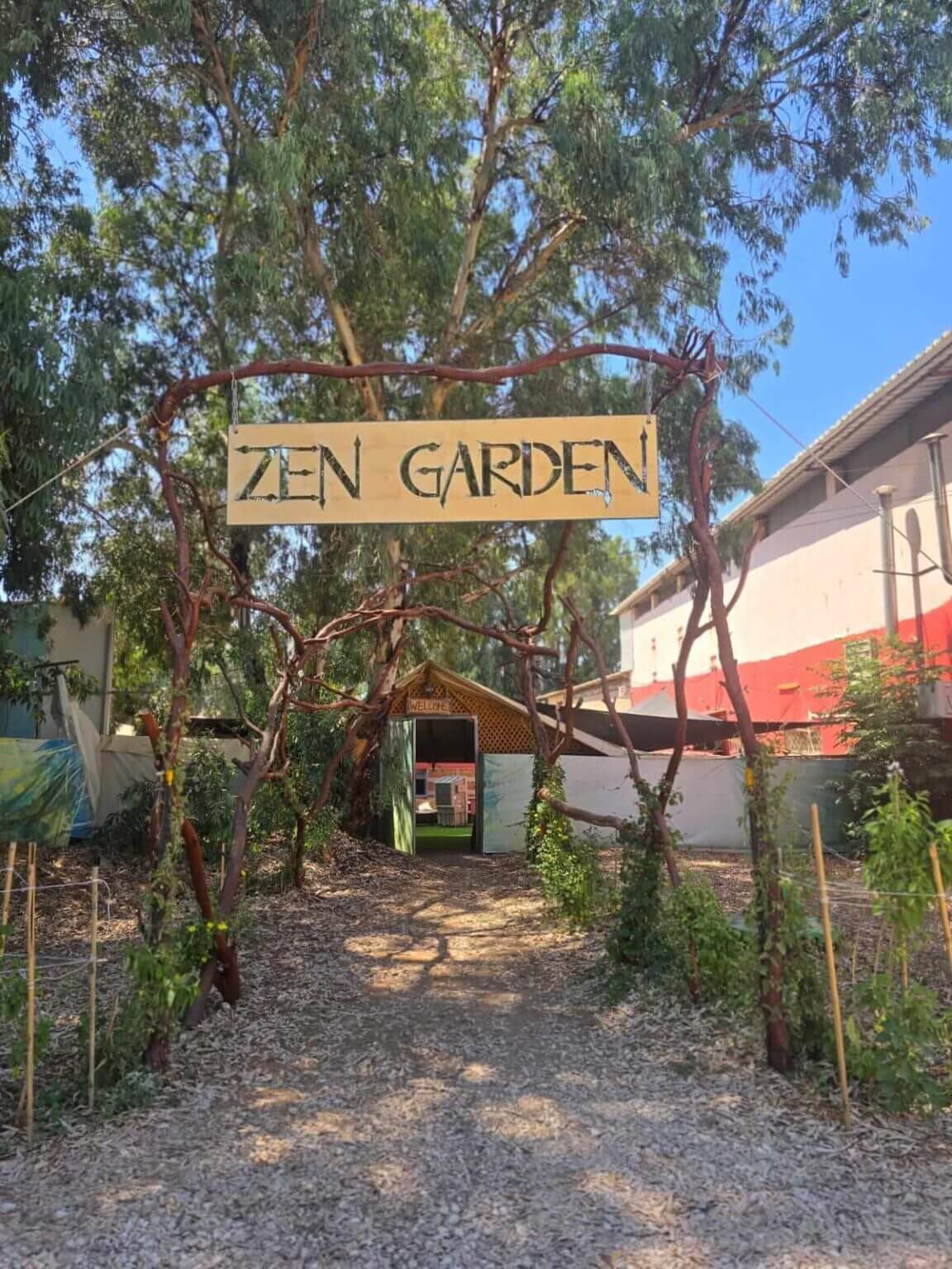 הכניסה ל-Zen Garden, פרדס חנה, עם שלט הכניסה בין עצי אקליפטוס